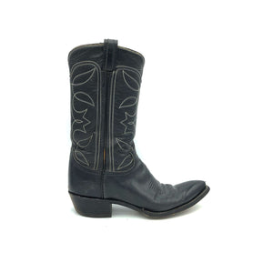 Authentic custom women's cowboy boots from the 1970's. Black cowhide leather with white stitch. Traditional western toe medallion. 11" height. 1 1/2" heel. Pointed toe. Black sole. These one-of-a-kind Tony Lama's were handmade in El Paso, Texas. Proudly made in the USA.